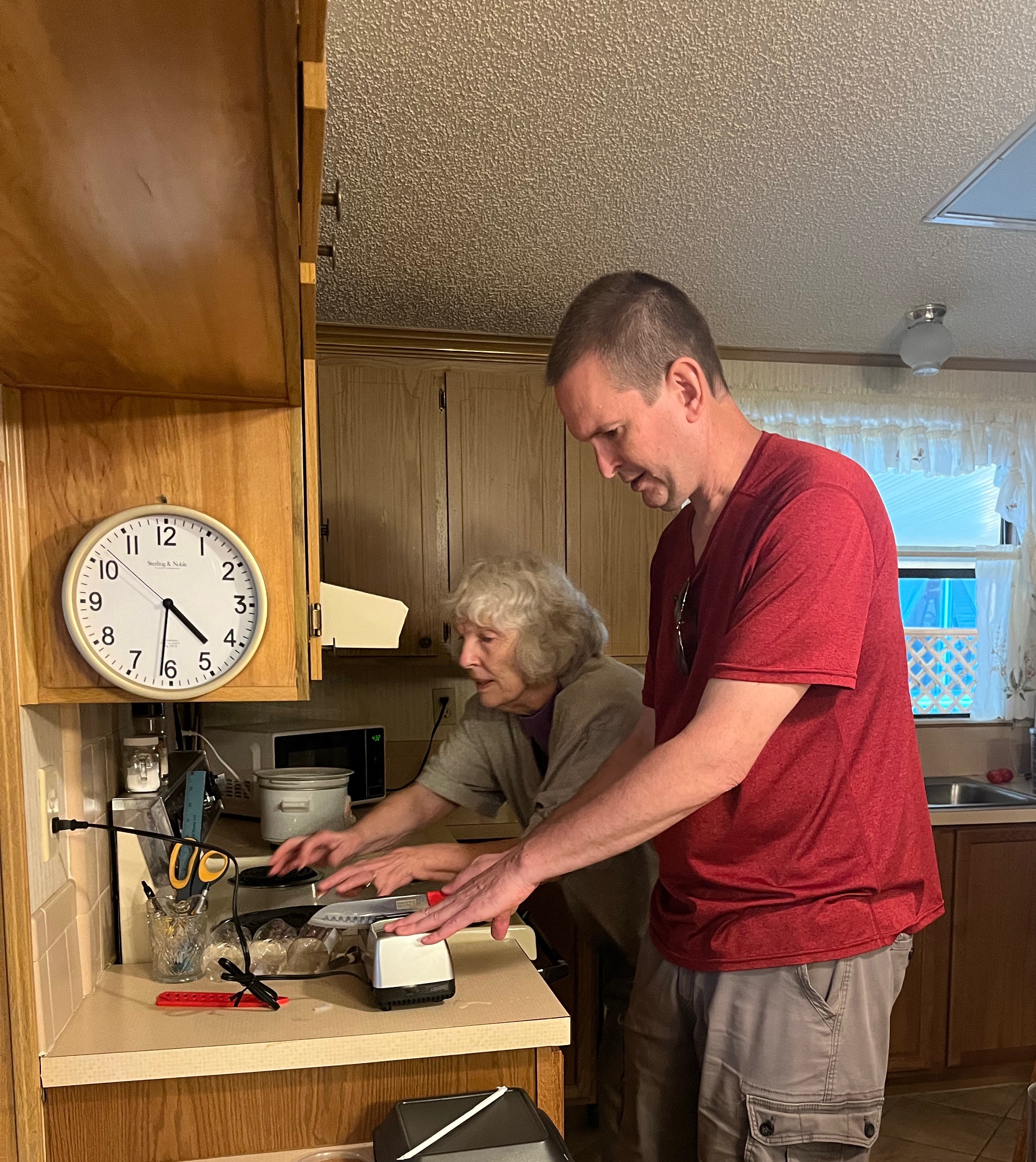 Erik brought his toy electrical knife sharpener to sharpen mom’s knives.